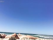 Nudist woman filming herself at the beach